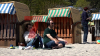 Familien genießen warmes Wetter - Kinder spielen im Sand - Besucher sonen sich in Strandkörben - großer Besucherandrang: 
